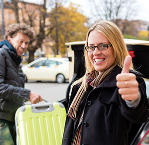 Taxifahrer hilft beim Ausladen, Frau ist vom Taxiservice begeistert