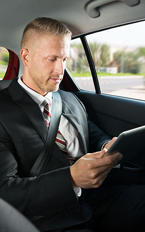 Geschäftsmann mit Tablet bei der Taxifahrt